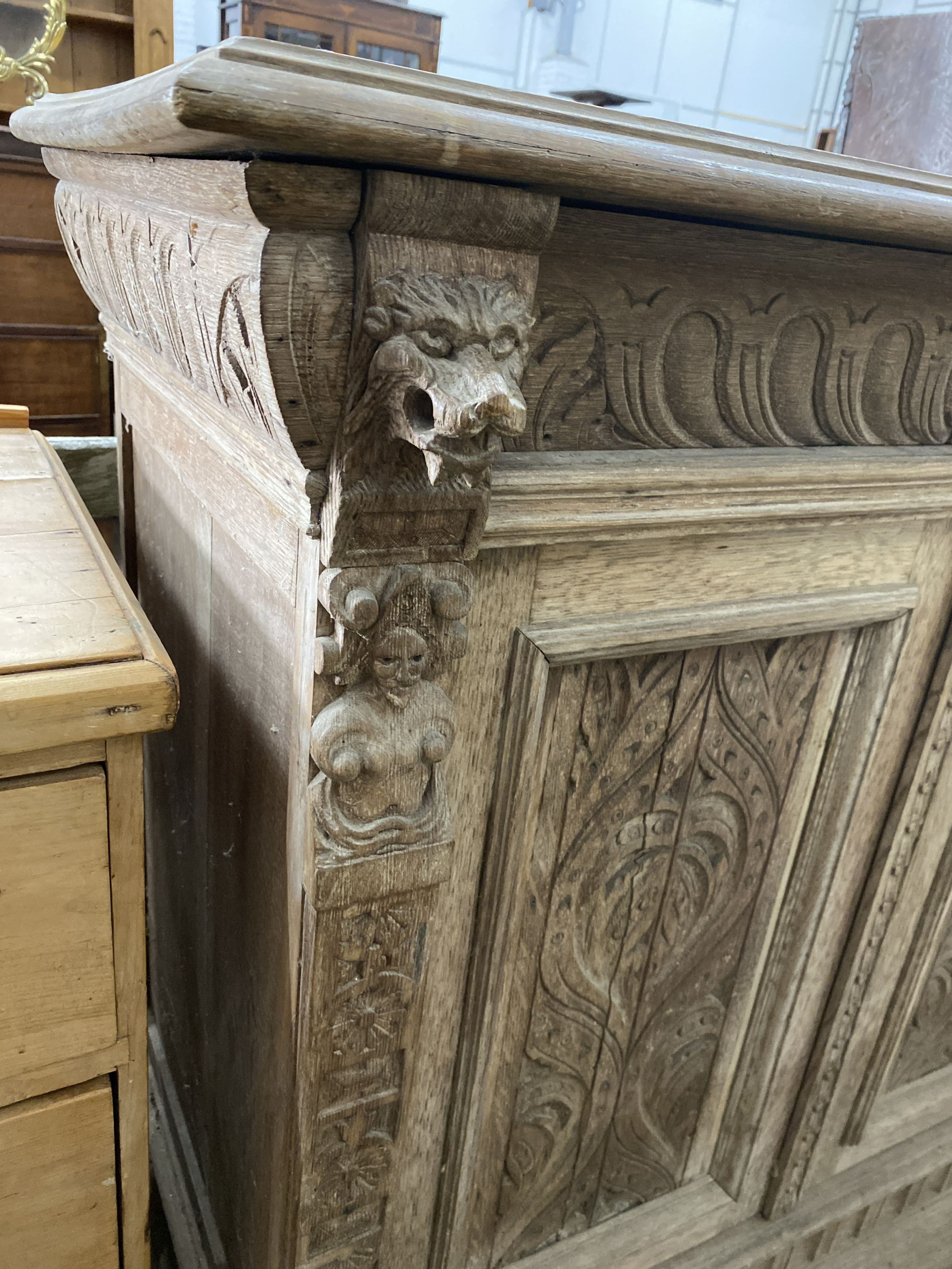 A late 19th century Flemish carved bleached oak two door side cabinet, width 106cm, depth 50cm, height 104cm